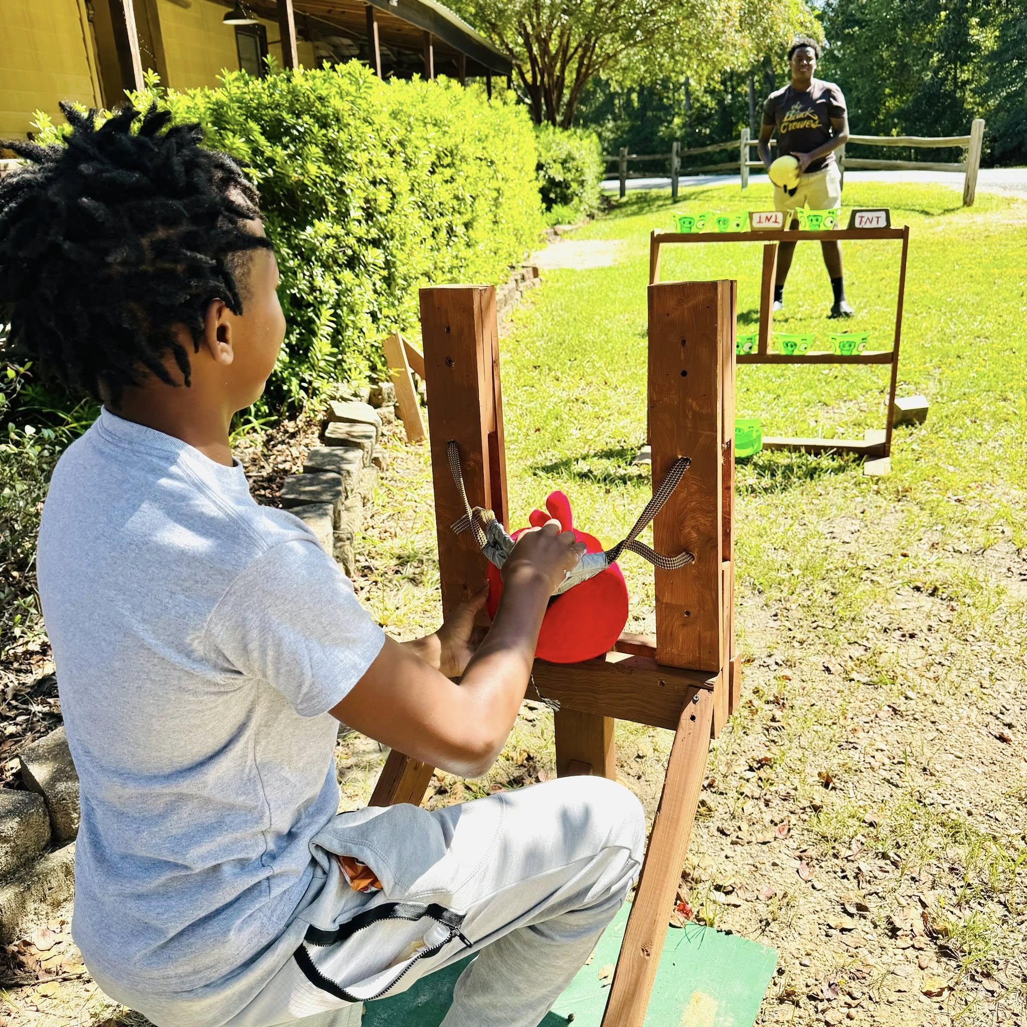 A boy about to slingshot a ball.